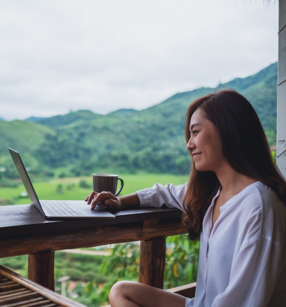 girl working on computer with a cup of coffee